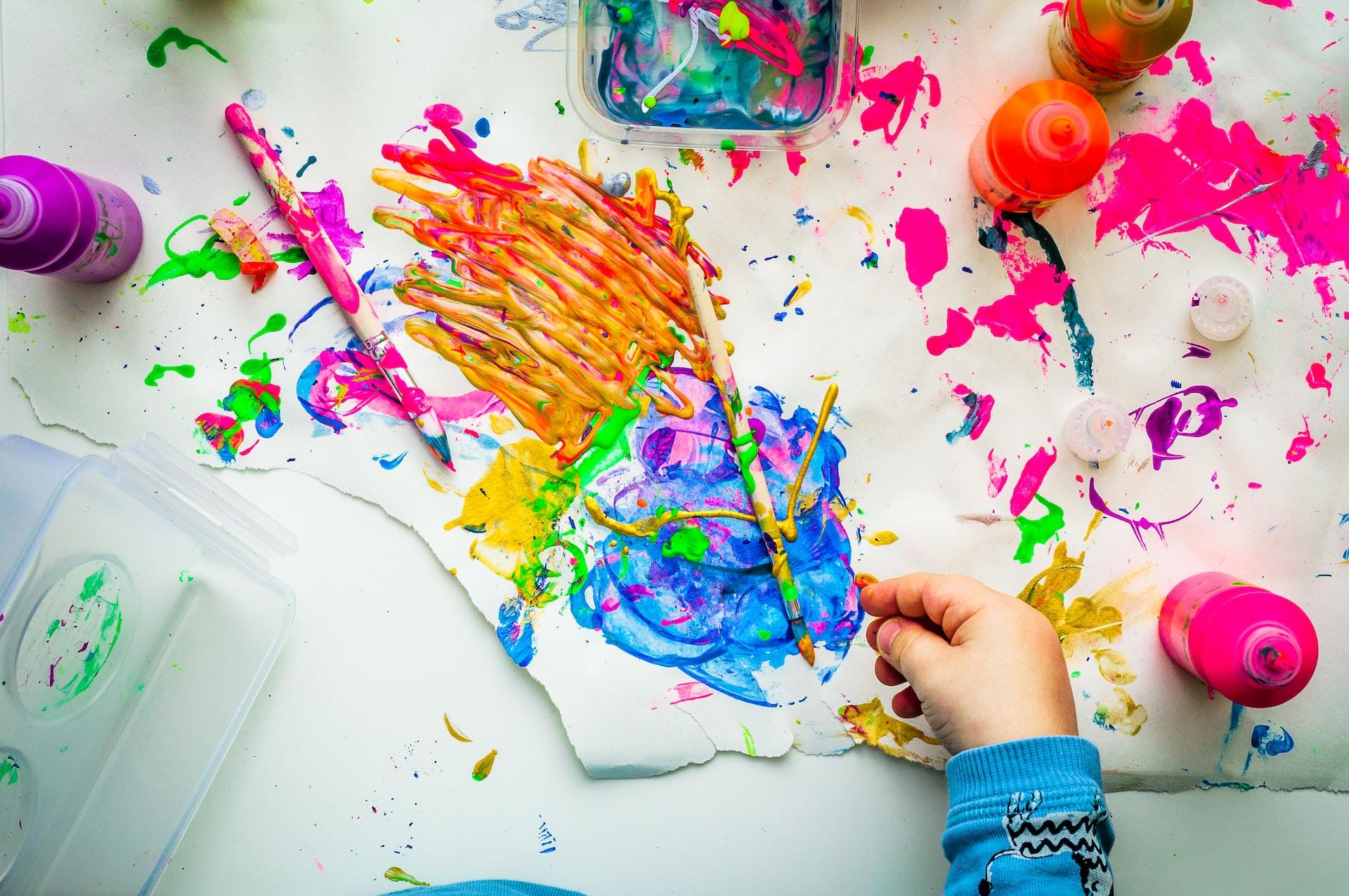 Child painting. 桌子上和纸上到处都是油漆